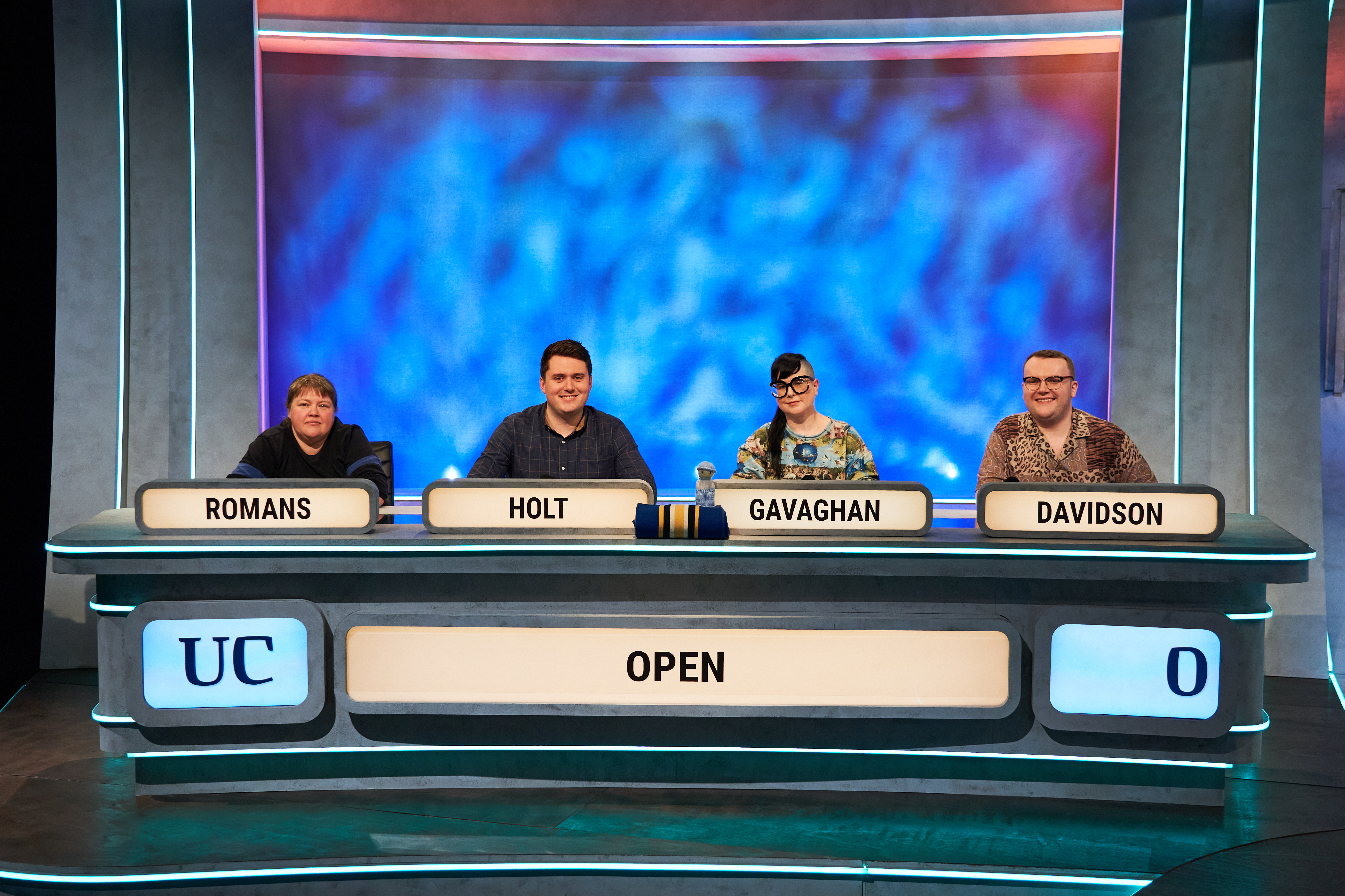 A photograph of the 2023 University Challenge team smiling at camera, from left to right Romans, Holt, Gavaghan, Davidson.